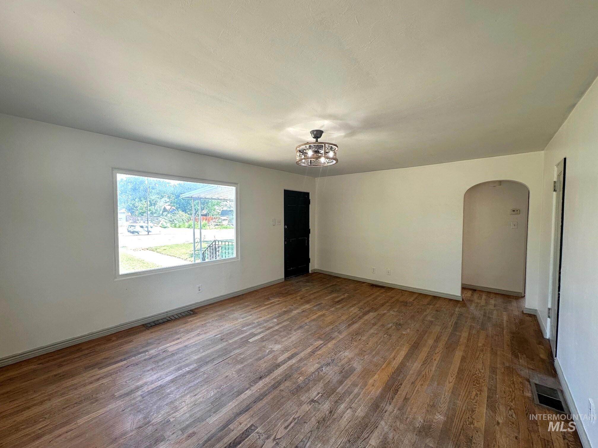 264 Southwest 10th Avenue Ontario, OR 97914 - Photo 2 of 26 Spare room with wood finished floors and arched walkways