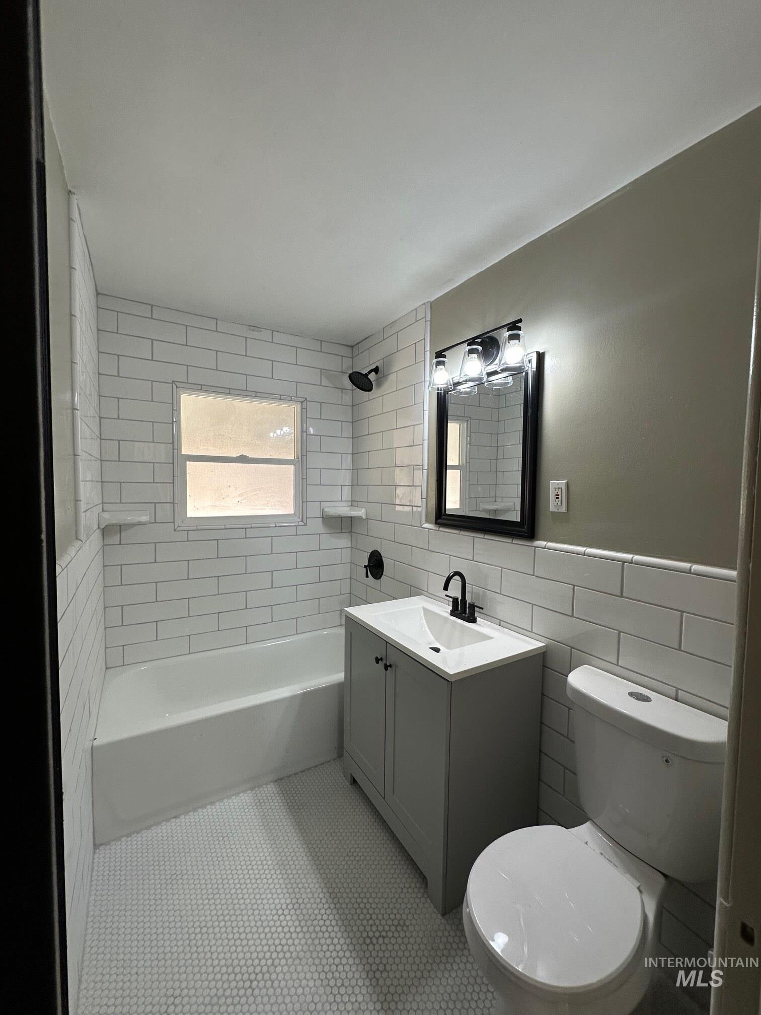 264 Southwest 10th Avenue Ontario, OR 97914 - Photo 10 of 26 Bathroom featuring vanity, tile walls, tile patterned floors, and shower / tub combination