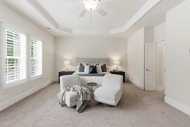 a bed sitting in a bedroom next to a window and a chandelier