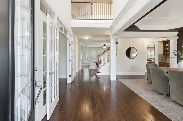 a view of a hallway with wooden floor and stairs