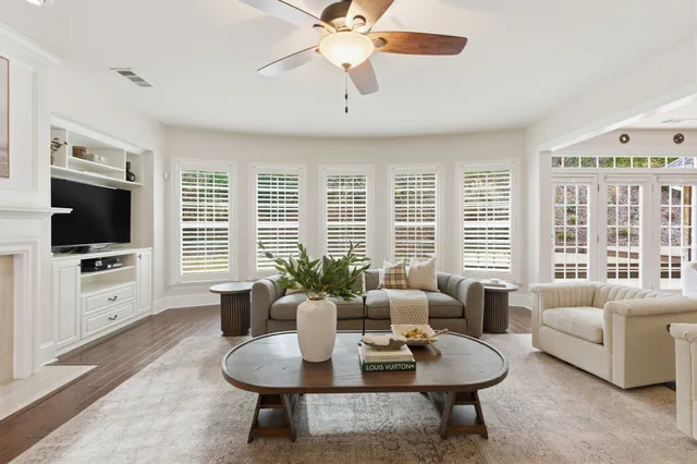 a living room with furniture a flat screen tv and a large window