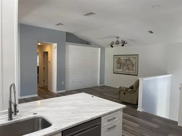 a kitchen with a sink and large mirror
