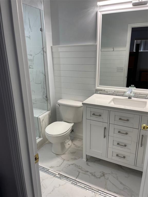 6412 Rosefinch Court, Unit 201 Lakewood Ranch, FL 34202 - Photo 10 of 14 a bathroom with a granite countertop toilet sink and mirror