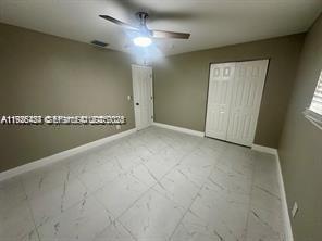 303 Northwest 7th Street, Unit 12 Hallandale Beach, FL 33009 - Photo 9 of 18 an empty room with a ceiling fan