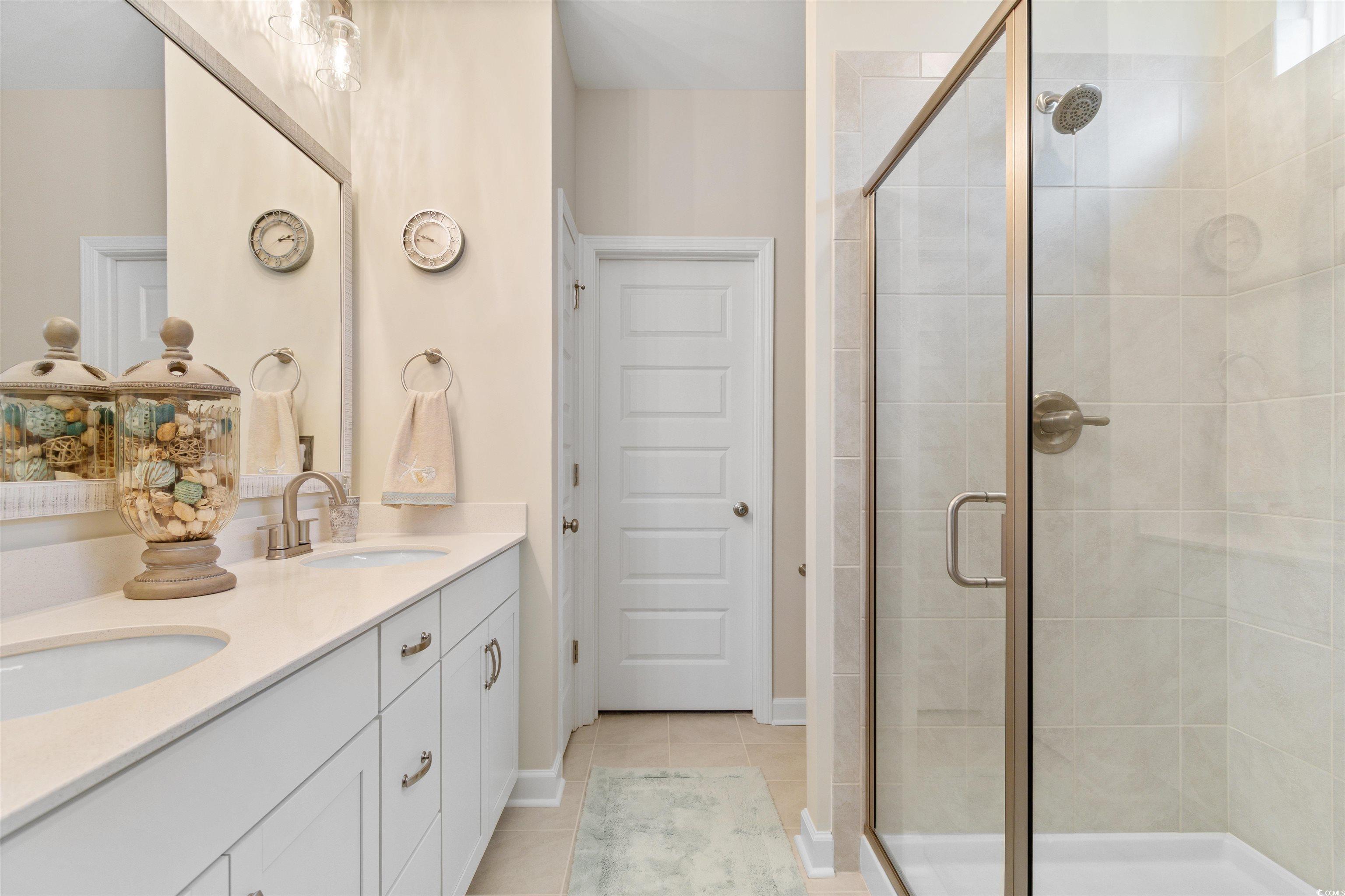 240 Sundew Loop Little River, SC 29566 - Photo 17 of 40 Full bathroom featuring a shower stall, double vanity, and tile patterned floors