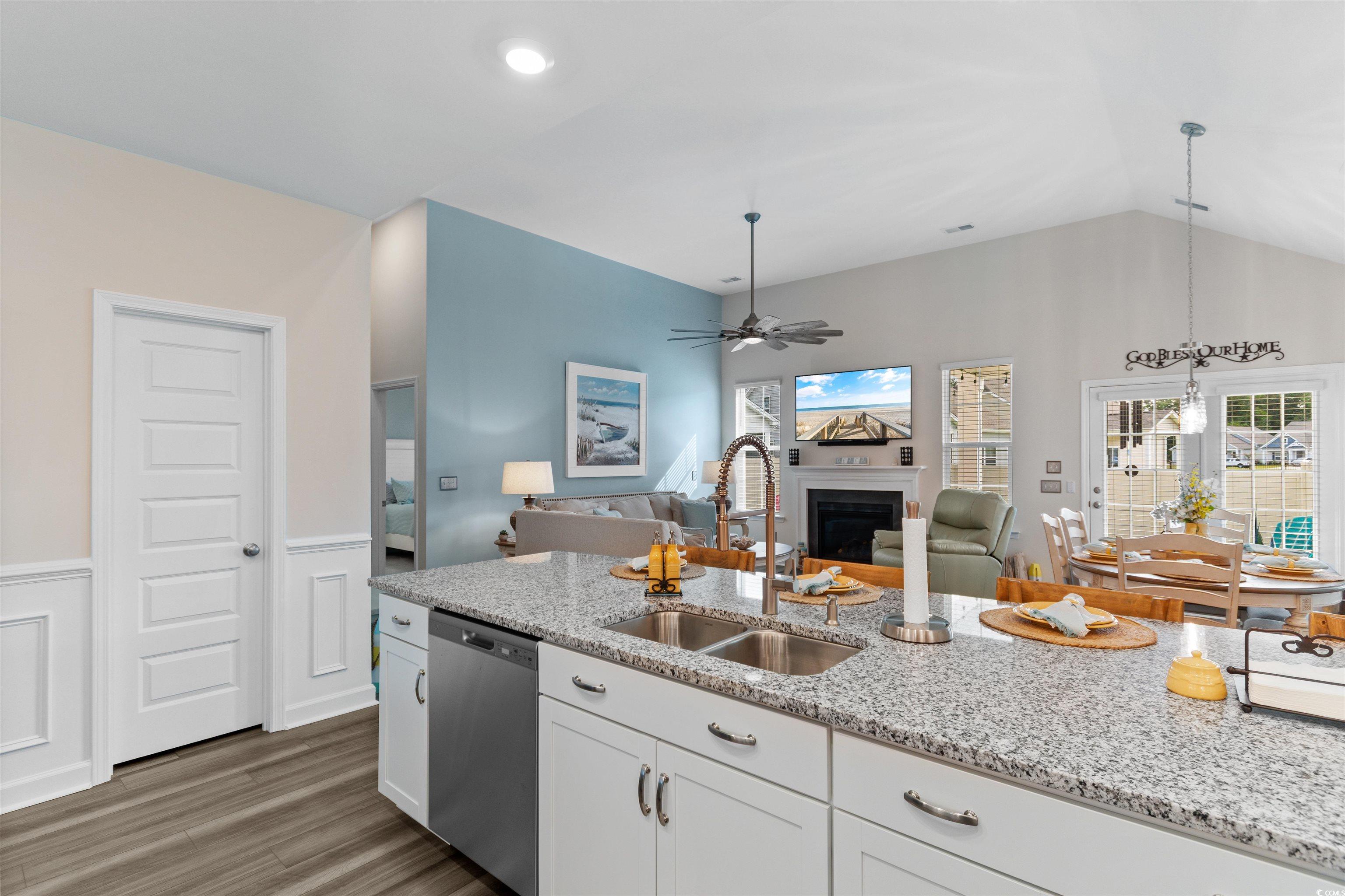 240 Sundew Loop Little River, SC 29566 - Photo 5 of 40 Kitchen with stainless steel dishwasher, wood finished floors, white cabinets, ceiling fan, and a fireplace