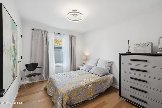 a view of a hallway with wooden floor and closet area