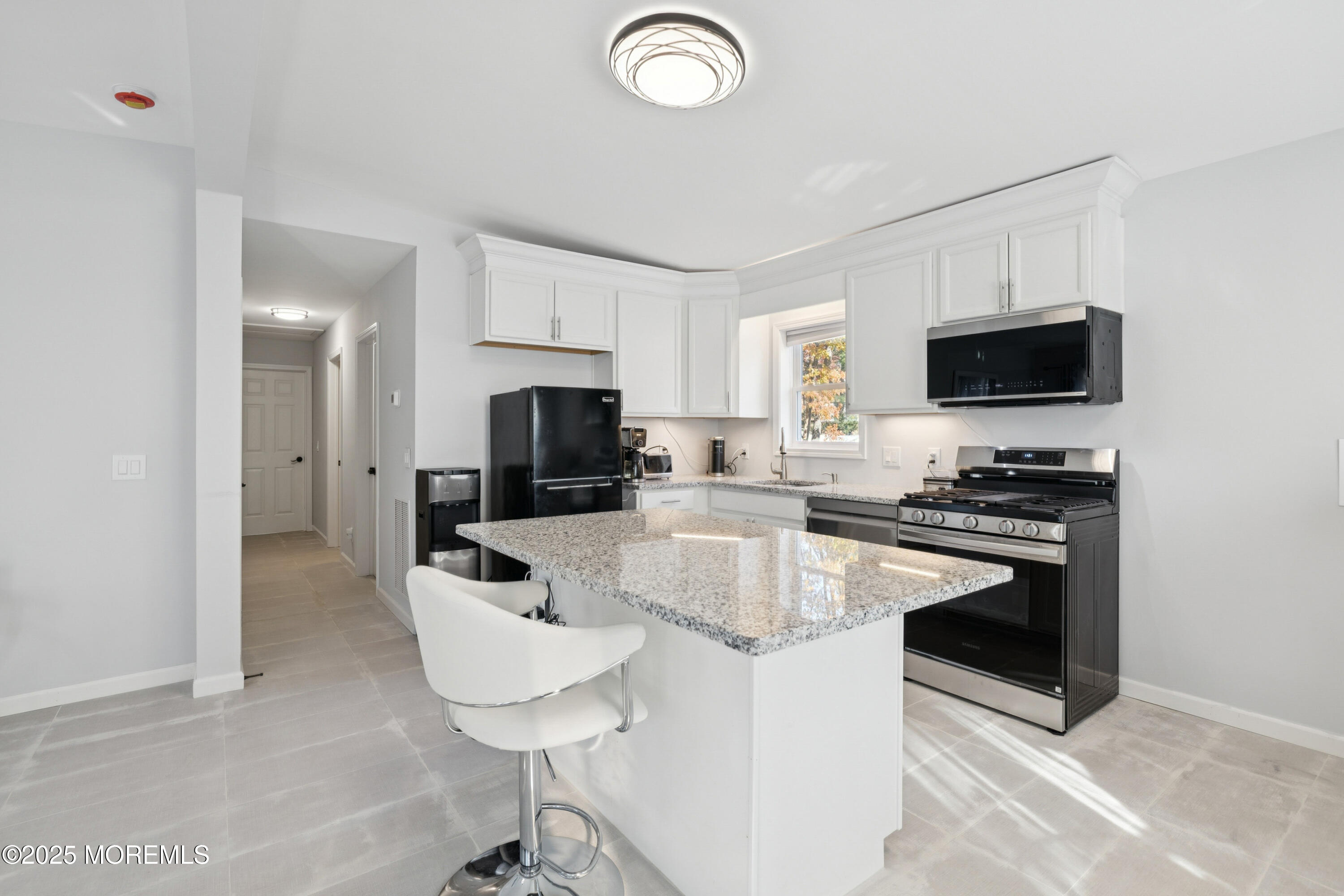 1569 Holly Road North Brunswick, NJ 08902 - Photo 4 of 29 a kitchen with stainless steel appliances a stove a sink a microwave a refrigerator and cabinets