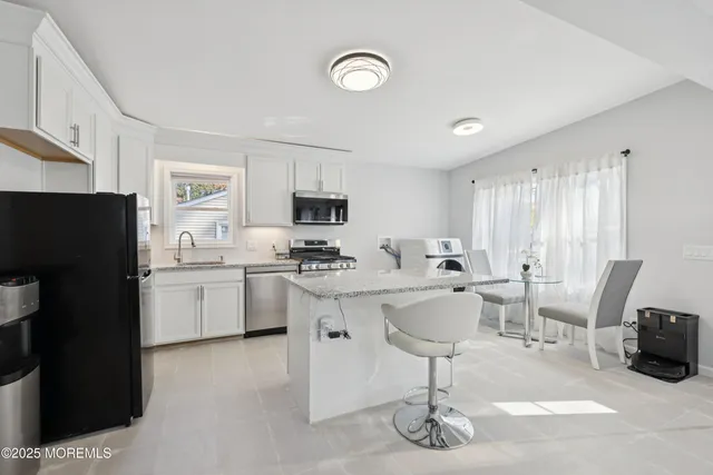 a kitchen with a sink a microwave a refrigerator and cabinets