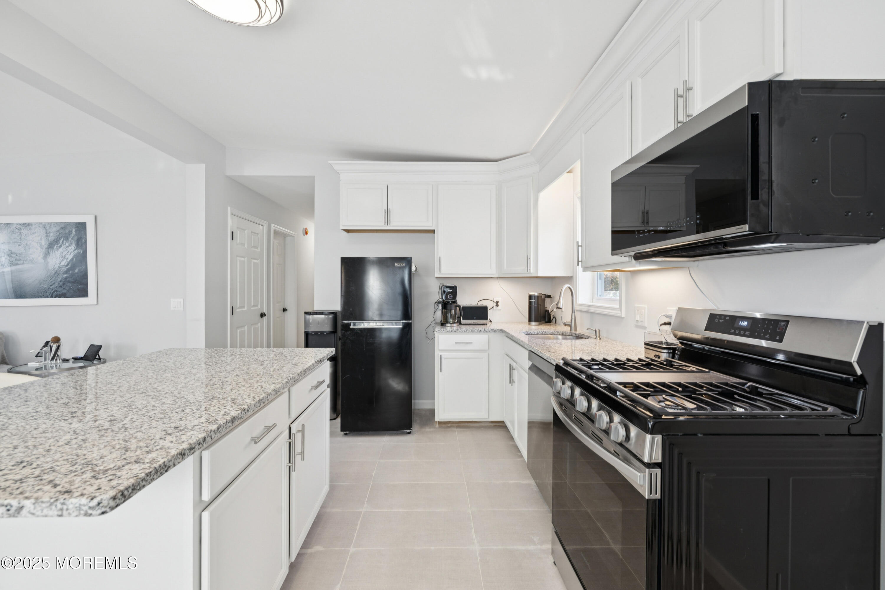 1569 Holly Road North Brunswick, NJ 08902 - Photo 8 of 29 a kitchen with a sink a microwave a refrigerator and cabinets