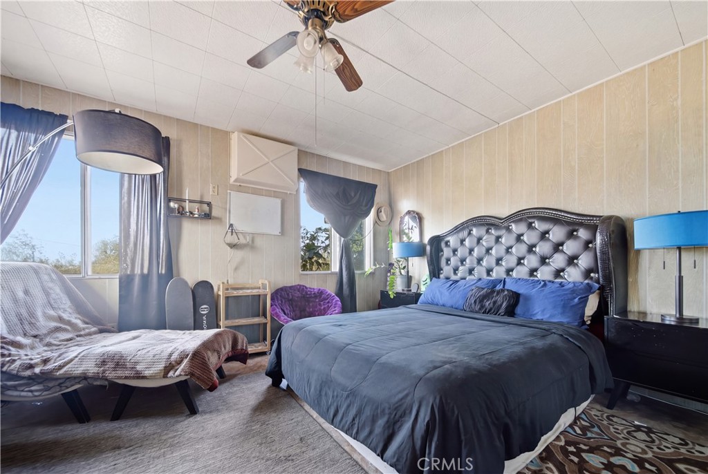 60153 Stearman Road Landers, CA 92285 - Photo 15 of 26 a bedroom with a large bed and a chandelier