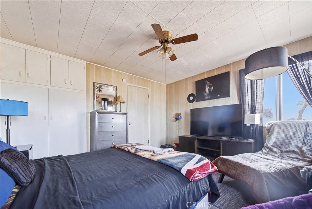 60153 Stearman Road Landers, CA 92285 - Photo 16 of 26 a bedroom with a bed and a flat screen tv