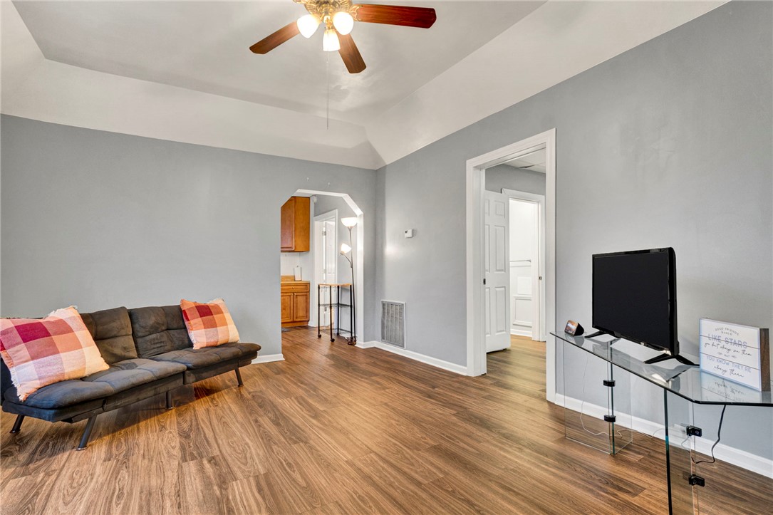 2505 East Brown Street Seneca, SC 29678 - Photo 8 of 43 This inviting living area features warm wood flooring and a classic ceiling fan, perfect for any gathering.