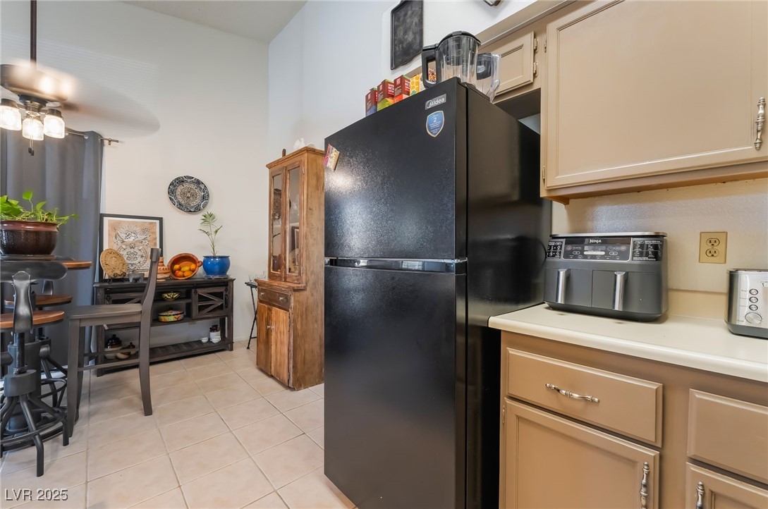 1575 West Warm Springs Road, Unit 2822 Henderson, NV 89014 - Photo 21 of 37 Kitchen featuring freestanding refrigerator, light tile patterned floors, ceiling fan, and light countertops