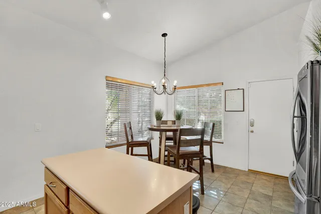 a kitchen with stainless steel appliances a stove a sink a microwave a dining table and chairs