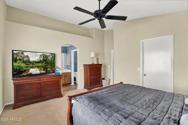 a bedroom with a large bed and a chandelier