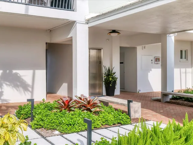a living room with furniture a flat screen tv and a large window
