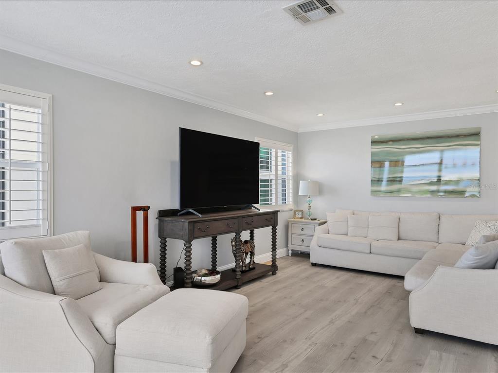 226 Golden Gate Point, Unit 44 Sarasota, FL 34236 - Photo 19 of 65 a living room with furniture and a flat screen tv
