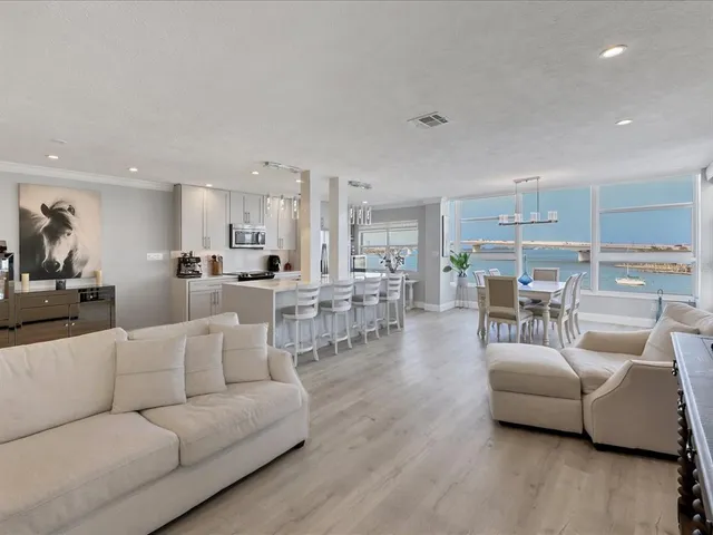 a living room with furniture a wooden floor and a large window