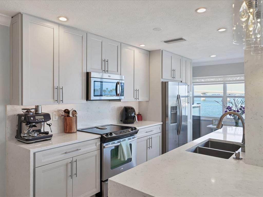226 Golden Gate Point, Unit 44 Sarasota, FL 34236 - Photo 25 of 65 a kitchen with a sink cabinets and stainless steel appliances