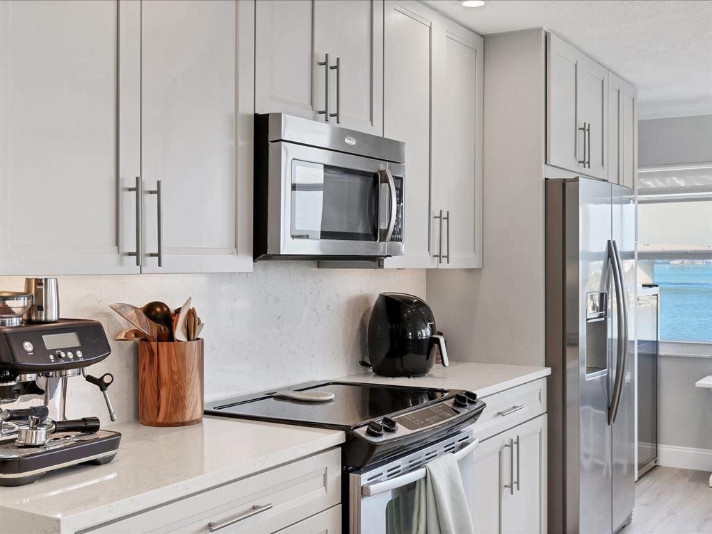 226 Golden Gate Point, Unit 44 Sarasota, FL 34236 - Photo 26 of 65 a kitchen with stainless steel appliances granite countertop white cabinets stove top oven and sink
