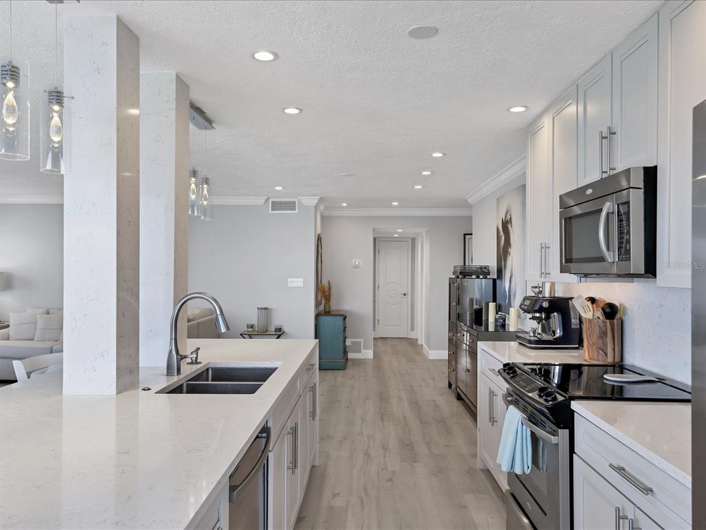226 Golden Gate Point, Unit 44 Sarasota, FL 34236 - Photo 29 of 65 a kitchen with stainless steel appliances a sink stove and refrigerator
