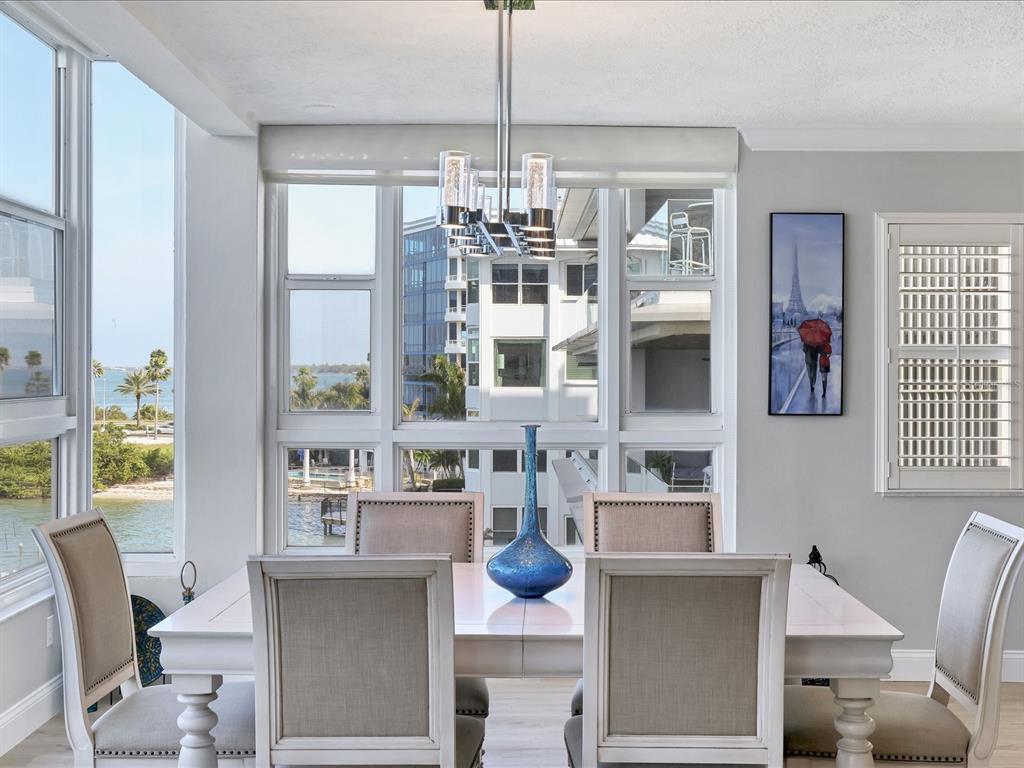 226 Golden Gate Point, Unit 44 Sarasota, FL 34236 - Photo 31 of 65 a view of a dining room with furniture large windows and wooden floor
