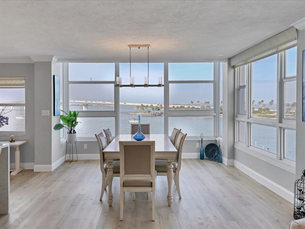 226 Golden Gate Point, Unit 44 Sarasota, FL 34236 - Photo 32 of 65 a dining room with furniture a large window and wooden floor