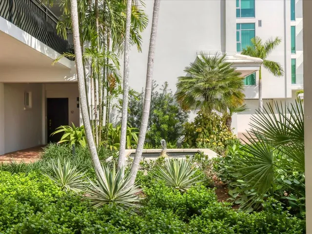 a kitchen with stainless steel appliances kitchen island granite countertop a table chairs and a refrigerator