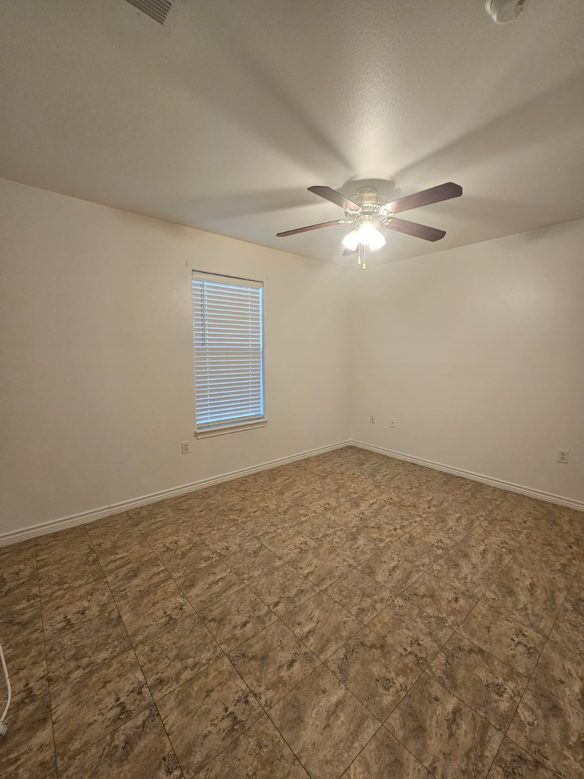 606 Trinity Street Lockhart, TX 78644 - Photo 15 of 23 A versatile room featuring durable tile flooring and a refreshing ceiling fan.
