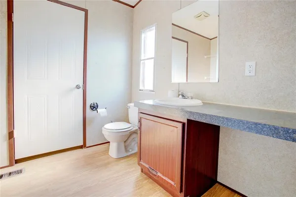 a bathroom with a granite countertop sink toilet a large mirror and a shower