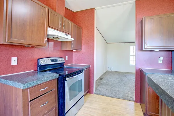a kitchen with stainless steel appliances granite countertop a stove and a microwave