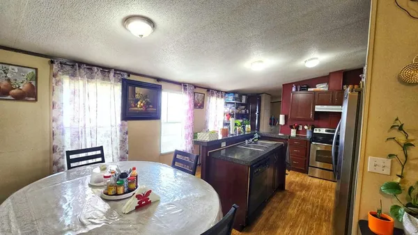 a view of a dining room with furniture a kitchen and chandelier