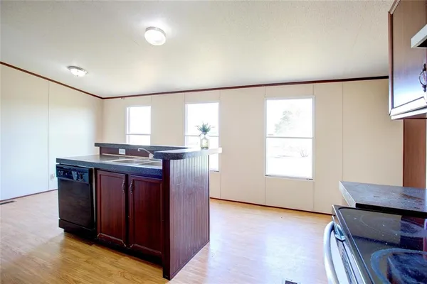 a kitchen with granite countertop a sink and a stove top oven