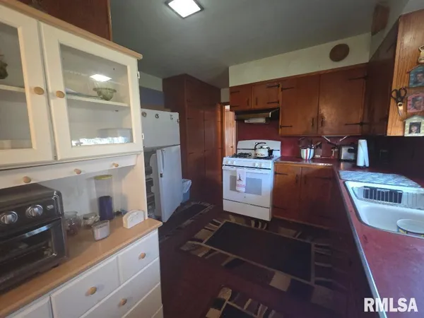 a kitchen with granite countertop a stove and white cabinets