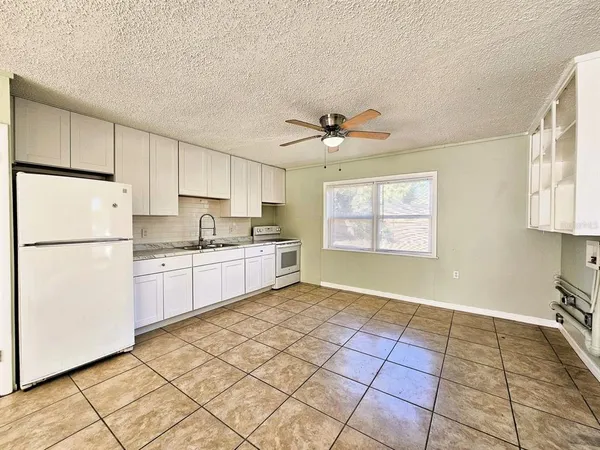 a kitchen with a refrigerator a sink and a stove top oven