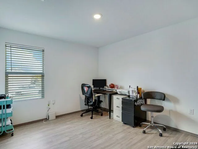 a view of a workspace with furniture and a window