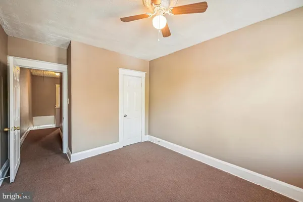 an empty room and chandelier fan