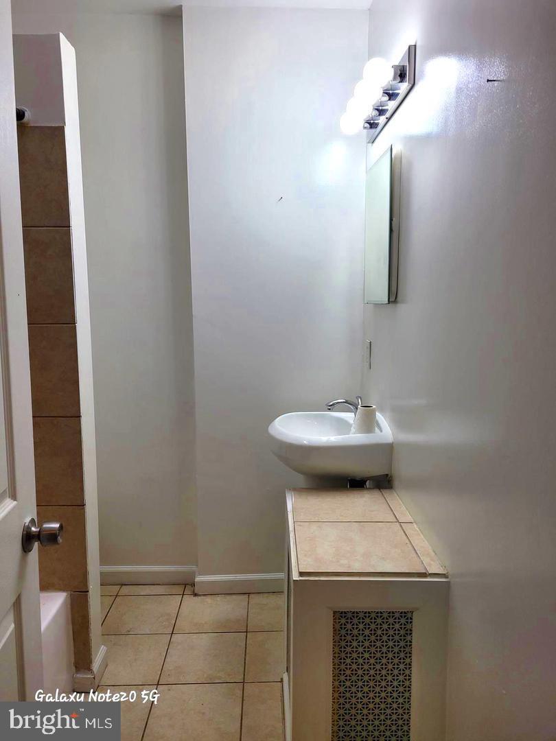 5632 Belair Road Baltimore, MD 21206 - Photo 21 of 32 a view of a bathroom with a sink and a mirror
