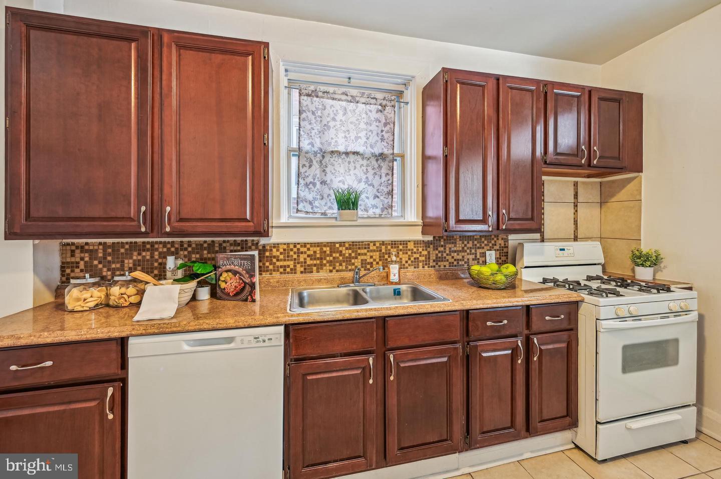 5632 Belair Road Baltimore, MD 21206 - Photo 5 of 32 a kitchen with stainless steel appliances granite countertop wooden cabinets a sink a stove a chimney and a counter space