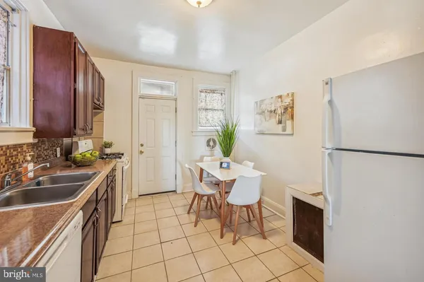 a kitchen with a sink chairs and refrigerator