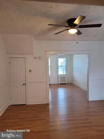 a view of a livingroom with wooden floor and a ceiling fan