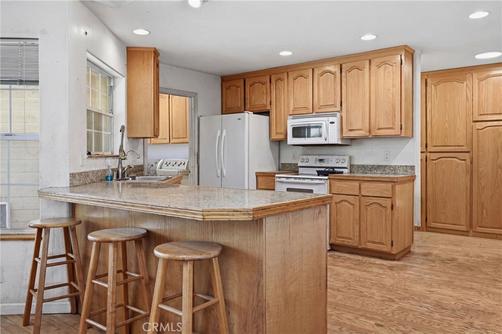 16965 Spruce Grove Road Hidden Valley Lake, CA 95467 - Photo 9 of 34 a kitchen with stainless steel appliances granite countertop a stove a sink a refrigerator white cabinets and a refrigerator