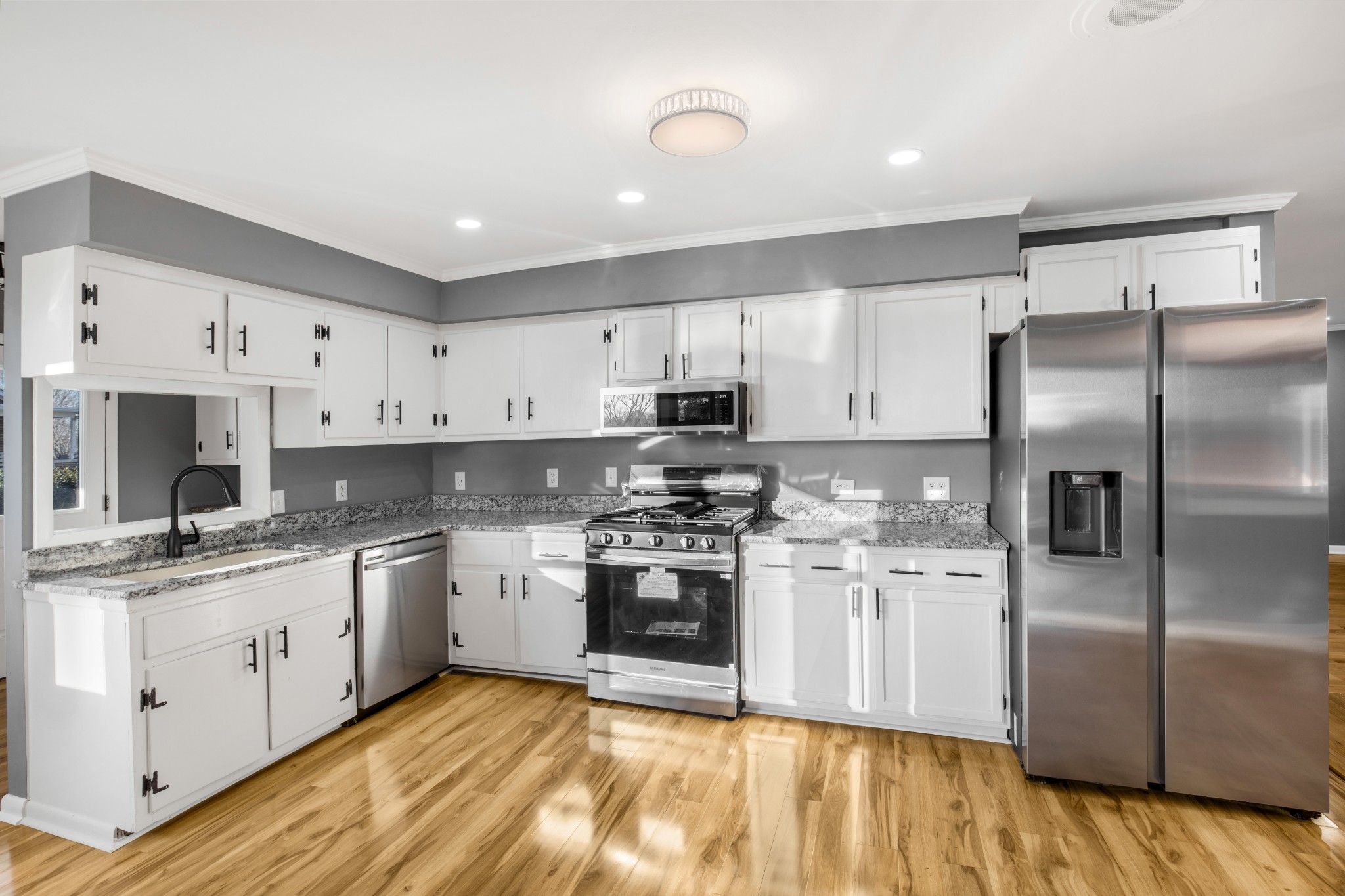 2209 Ruth Street Springfield, TN 37172 - Photo 20 of 31 a kitchen with stainless steel appliances granite countertop a stove a sink dishwasher a refrigerator and white cabinets with wooden floor