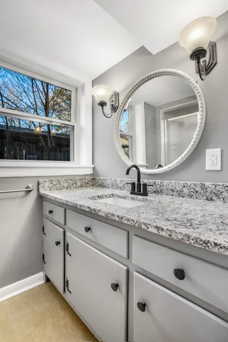 a bathroom with a granite countertop sink and mirror