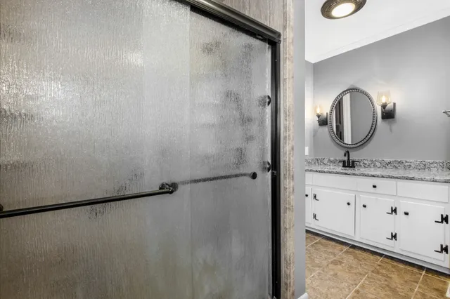 a bathroom with a granite countertop sink and a mirror