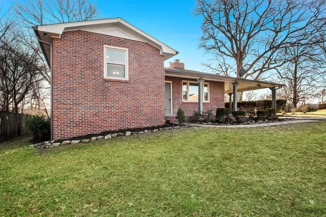 a front view of a house with a yard and trees