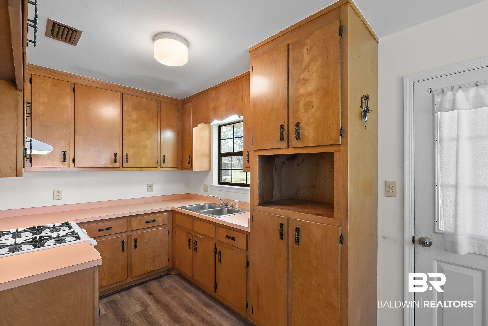 20540 Lacey Road Silverhill, AL 36576 - Photo 10 of 40 Kitchen featuring wood cabinetry, laminate countertops, dual basin sink, and wood-finish flooring