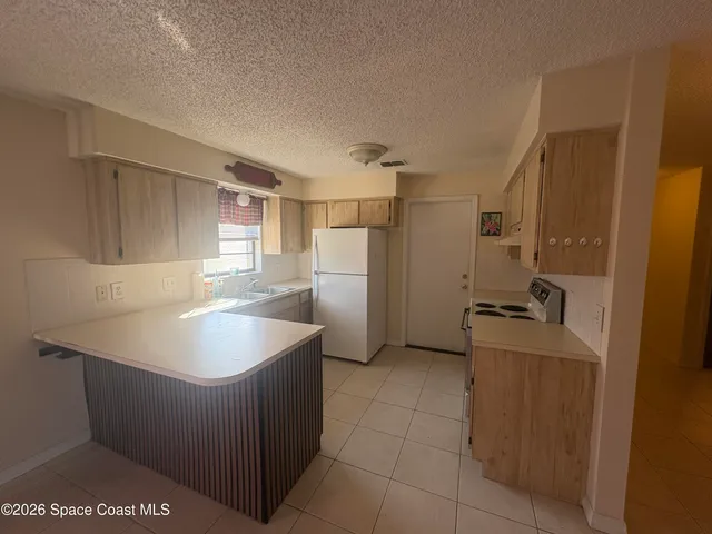 a kitchen with a sink refrigerator and cabinets