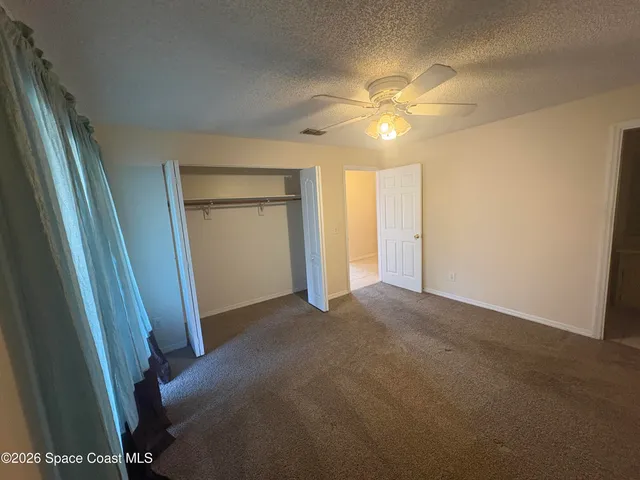 a view of a hallway with a chandelier fan